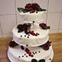 Tolle Hochzeitstorte mit feinem weißem Massa Ticino und roten Rosen.